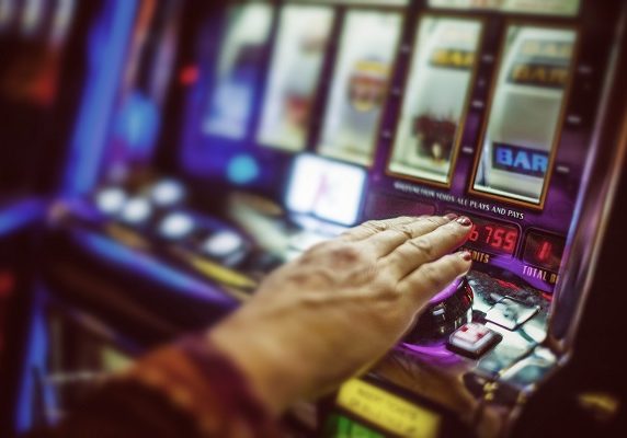 Woman's hand on a slot machine.